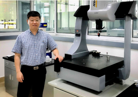 Bob Zhao standing next to bearing machine